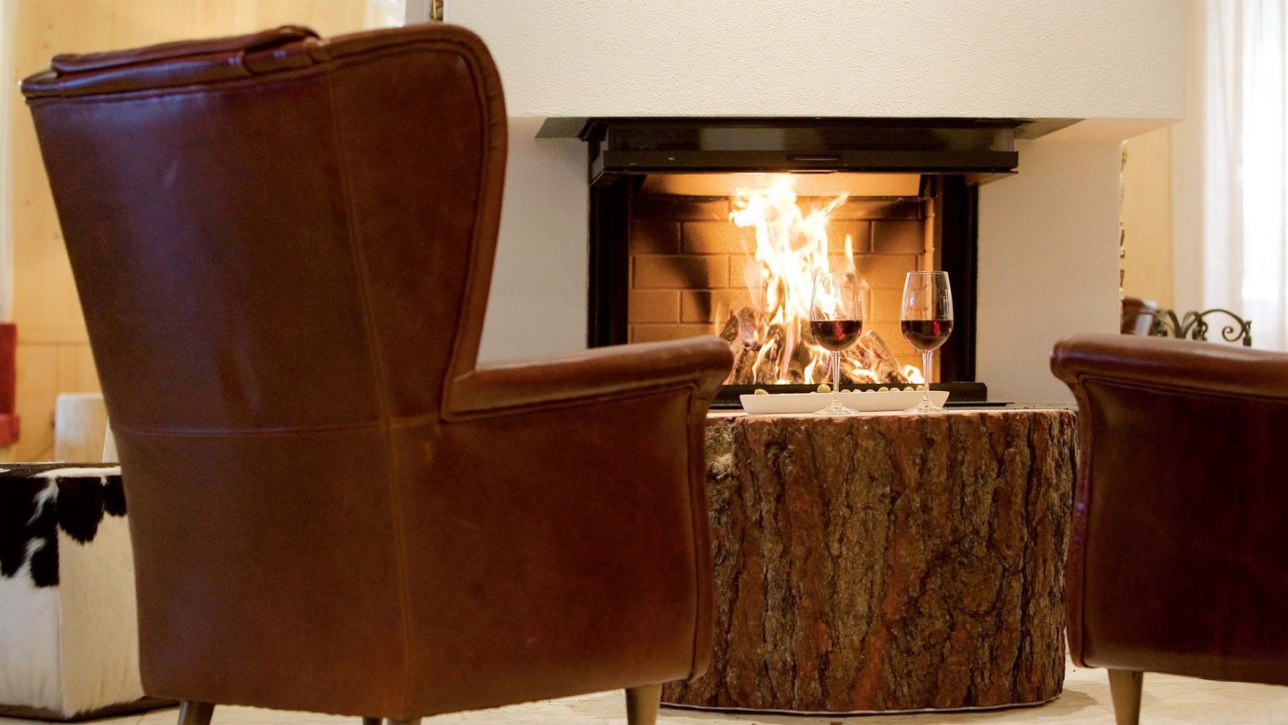 Gemütliche Sessel am Kamin in der Lounge vom Familienhotel Bella Vista, Trafoi
