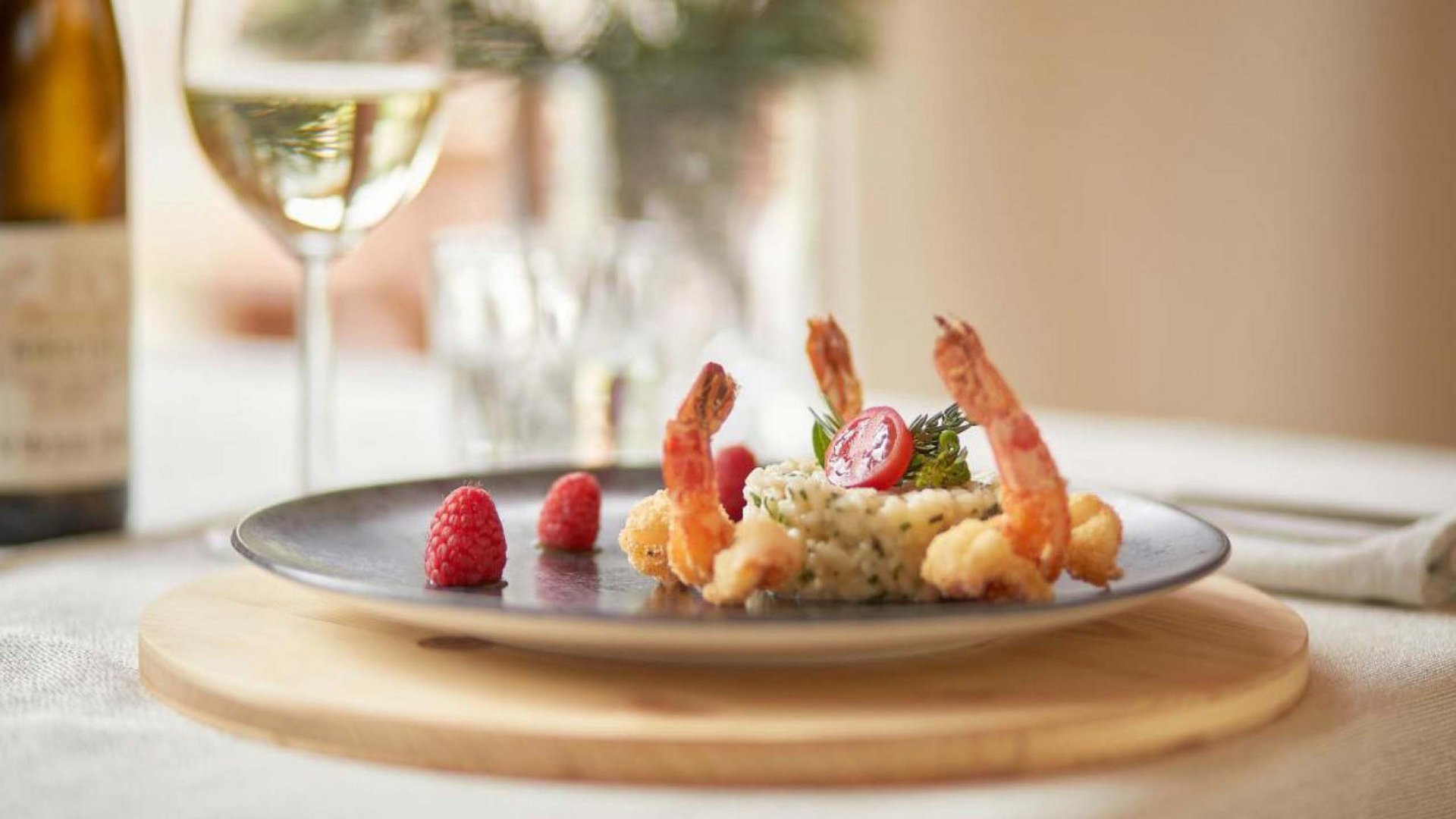 Elegantly plated shrimp with accompaniments and a glass of white wine at Hotel Bella Vista, embodying the hotel's fine dining experience.